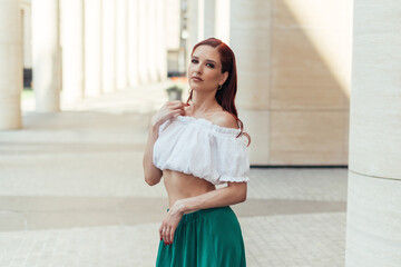 Portrait of a girl in summer clothes on the background of a modern building