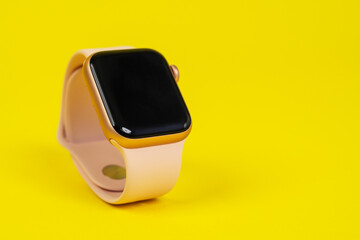 May 29, Rostov, Russia: Apple Watch Series 6 with pink rubber strap on yellow background, copy space. Smart device for an active lifestyle