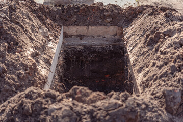 Freshly dug grave pit at cemetery, a close-up. - obrazy, fototapety, plakaty
