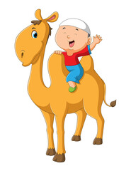 The little boy is sitting on the cute camel