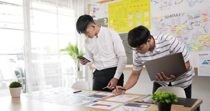 Two asian men checking to task