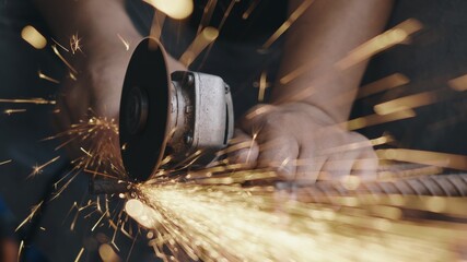 Worker man using electric wheel grinding and cutting on steel structure have spark from the...