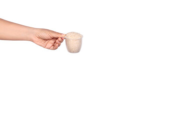 Women hand holding Plastic measuring cup with jasmine rice isolated on white background 