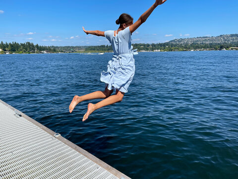 teenage girl jumping into the lake