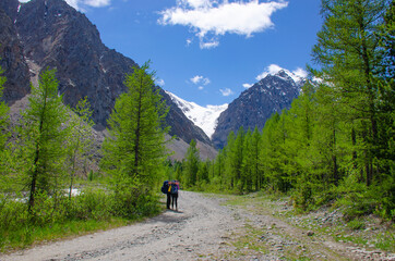 Fototapeta na wymiar Group of tourists man and woman goes to mountains glacier Actru Russia