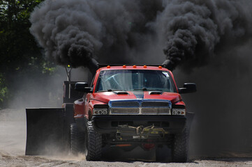 red truck at a tractor pull meeting billowing black smoke