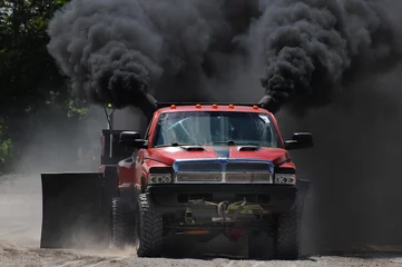 Foto op Canvas red truck at a tractor pull meeting billowing black smoke © Terry