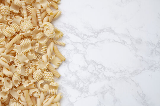 Varieties of Dry Pasta Left Border on Marble Surface