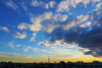 青から黄色への美しい空のグラデーションの映える東京の空とビルやタワー等の建造物立ち並ぶ風景