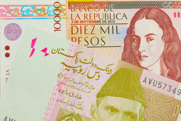 A macro image of a brown ten thousand bank note from Colombia paired up with a pink and grey ten rupee note from Pakistan.  Shot close up in macro.