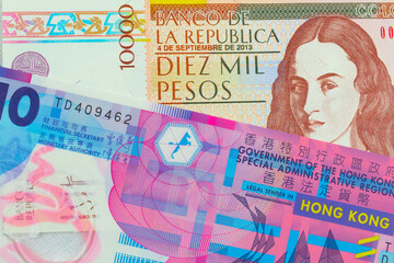 A macro image of a brown ten thousand bank note from Colombia paired up with a pink and purple, plastic ten dollar bill from Hong Kong.  Shot close up in macro.