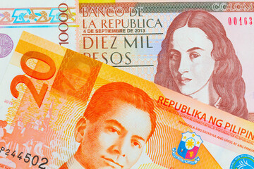 A macro image of a brown ten thousand bank note from Colombia paired up with a orange and white twenty piso note from the Phillipines.  Shot close up in macro.
