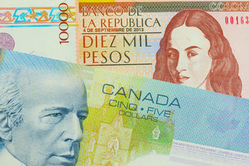 A macro image of a brown ten thousand bank note from Colombia paired up with a blue five dollar bill from Canada.  Shot close up in macro.