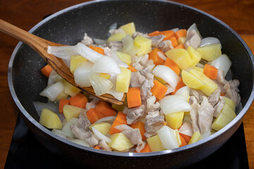 Stir-fried pork with mixed vegetables in a hot pan.