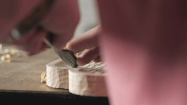 a carpenter processes a pine wood board with a chisel. artisan makes a tea tray. the art of woodworking. work with hand carpentry tools. woodworking sounds