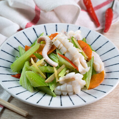 Stir-fried neritic squid with celery. Delicious homemade seafood with vegetable meal.