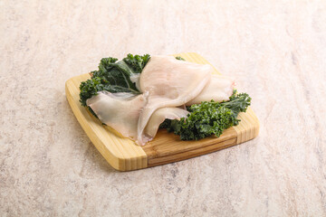Raw squid over wooden board