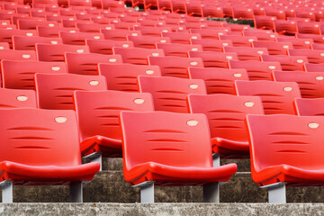 Rows of empty seats in a stadium. Red plastic seats