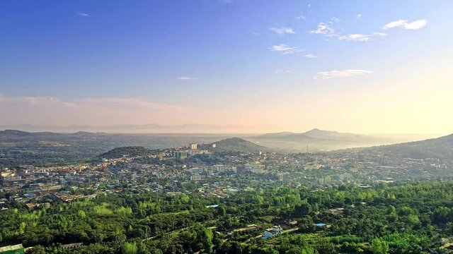 Aerial panorama of Henan, China at sunrise, cities between mountains and forest