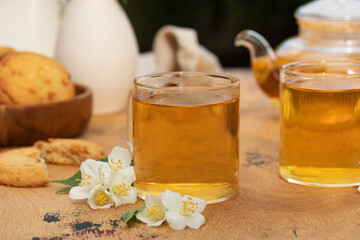 Obraz na płótnie Canvas Green Chinese tea with jasmine in a mug with jasmine flowers.