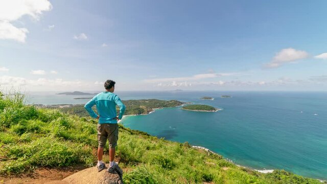 Timelapse of Travel man stands on the high mountain at Phahindum view point popular landmark in Phuket Thailand and shoots video and photo with smartphone Concept vacation travel Phuket Thailand