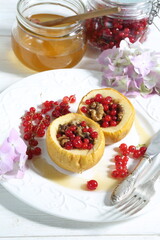 Baked apples with honey, walnuts, currants on a white background