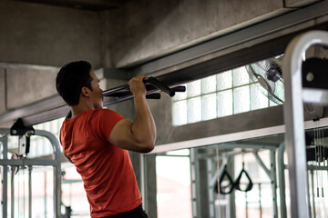 Strong fit man pulling up bar at sport gym