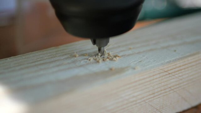 Penetrating and drilling into soft wood batten construction wood with cordless drill, close up