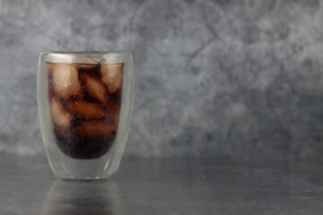 glass of ice cola isolated on gray background