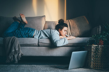 Bored woman laying on the sofa. Woman working from home.