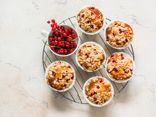 Red currant vanilla mini oatmeal muffins with sugar crumble on a light stone background, top view