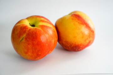 Side view of two nectarines on white background