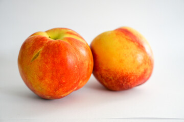 Angle view of two nectarines on white background
