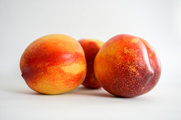 Side view of three nectarines on white background