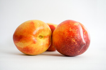 Side view of three nectarines on white background