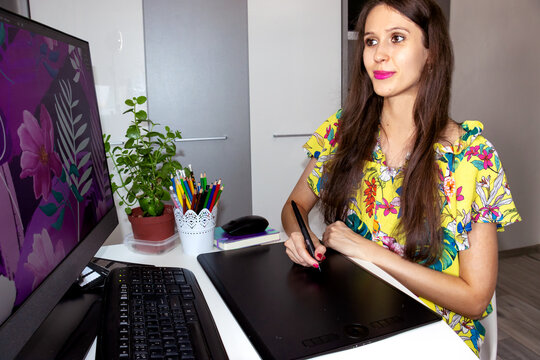 A Smiling Woman, Graphic Designer, Illustrator, Fashion Designer is Working on a Computer and Drawing on the Graphic Tablet. Creating the Illustration for the Fabric. Young, Successful Business woman.