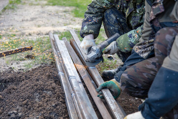 A worker grinds metal at a construction site.