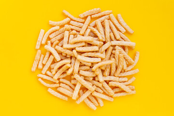 Prawn cracker sticks on yellow background. Shrimp crisp rice snack