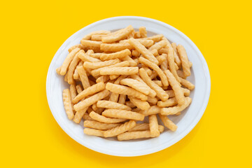 Prawn cracker sticks on yellow background. Shrimp crisp rice snack