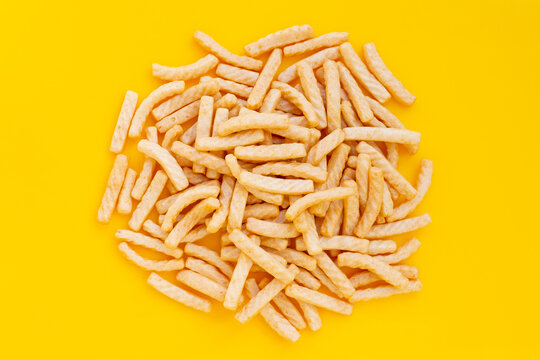 Prawn cracker sticks on yellow background. Shrimp crisp rice snack
