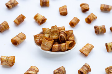 Dried banana rolled chips on white.
