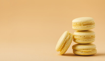 Stack of yellow macaroons with shallow depth of field on the yellow flesh colored background.