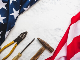 LABOR DAY. Hand tools and the Flag of the United States of America lying on the table. View from above, close-up. Congratulations to family, relatives, friends and colleagues. National holiday concept