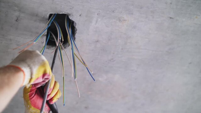 electrician strips wires in the apartment