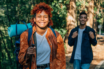 young multiethnic couple with backpacks hiking or trekking