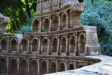 Naklejka premium The ruins of the Roman Colosseum built in the park, architectural elements of ancient buildings.