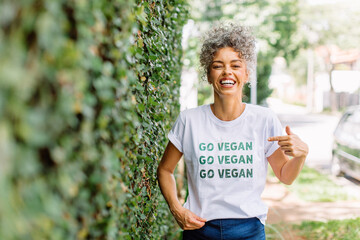 Happy mature woman advocating for veganism outdoors - obrazy, fototapety, plakaty