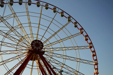 Round Ferris wheel on a background of blue sky.