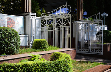 Openwork white gates in the city on a sunny summer bright day.