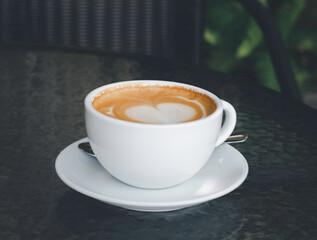 Lateart hot coffee in the morning on a cafe with vintage light as background.
